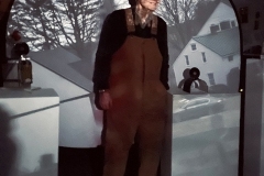 Julian Strauss standing in projection of barns and farm with camera obscura