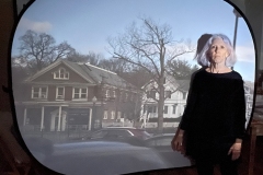 Lonna stands with screen projection of village of Pawling using camera obscura