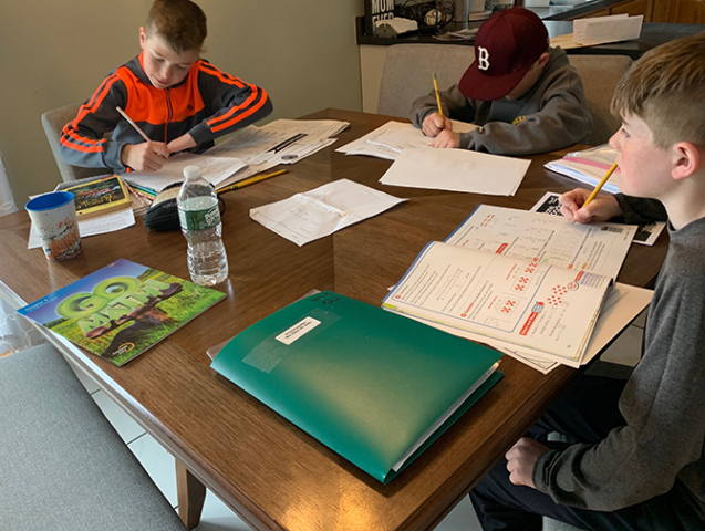 Three students at home schooling during pandemic