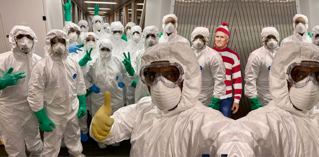 VP Pence no mask in where's waldo stripes standing with masked, ppe wearing medical team