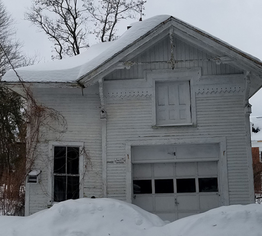 white wooden garage victorian trim covered in snow