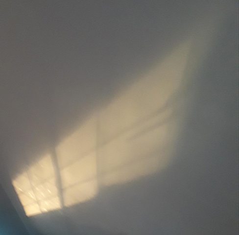 sunlight reflection from window on white wall