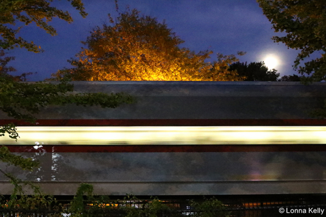 speeding train blurs windows full moon