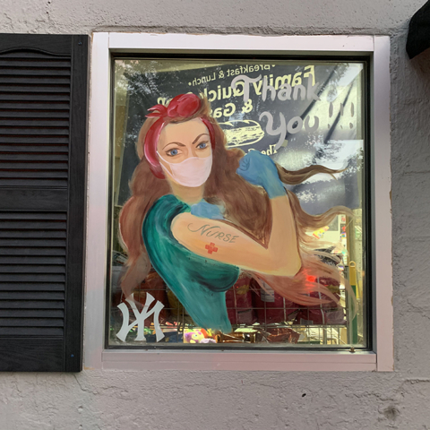 store window with painting of woman flexing muscle TY nurses