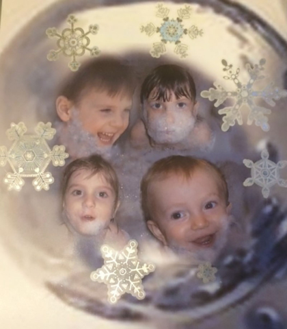faces of four young children in a christmas tree ball
