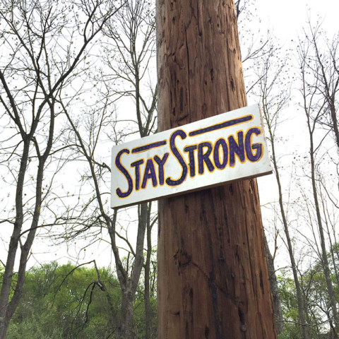 hand painted sign Stay Strong on telephone pole