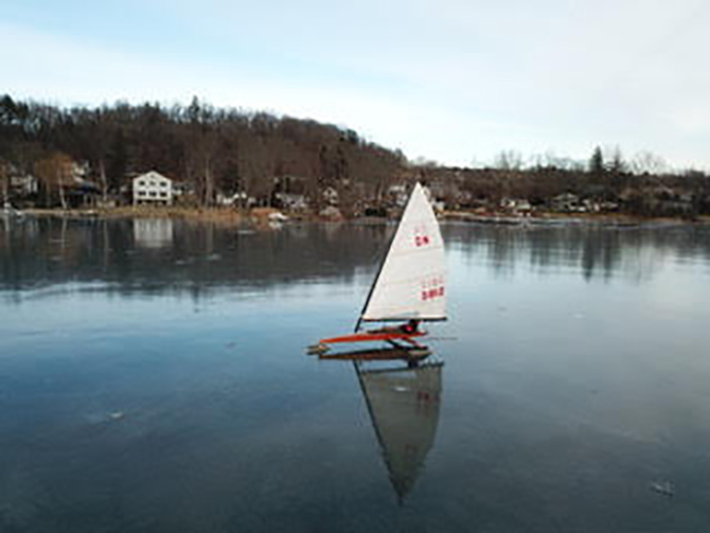 ice boat red body white sail on Peach Lake