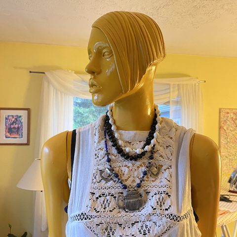 mannequin from elbows up showing necklaces she is wearing