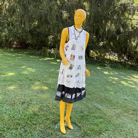 finished mannequin standing on green lawn pine trees in background