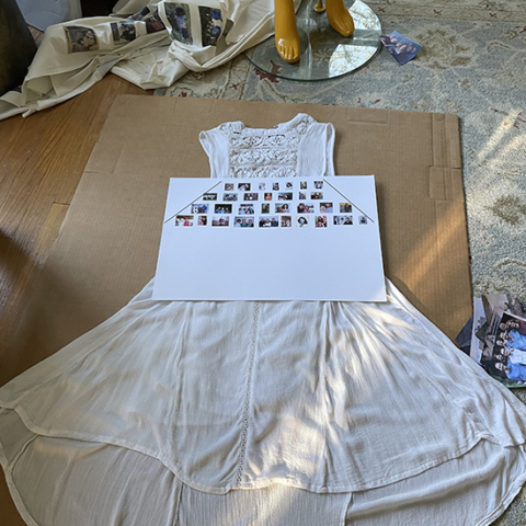 white cotton dress on large piece of cardboard with printout of layout of images to be added