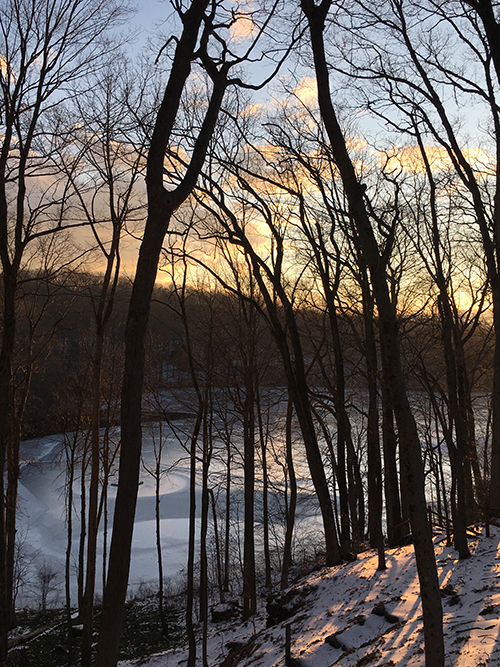 frozen lake, forested shore at sunset